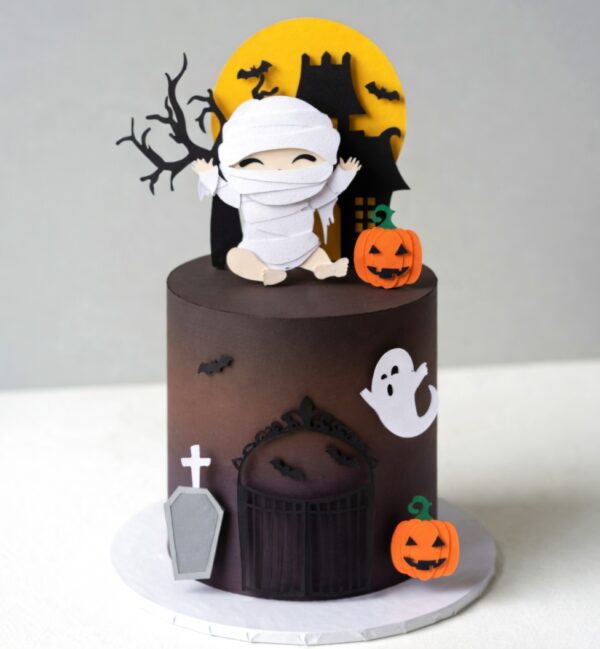 Topo de bolo Halloween infantil com bebê múmia, lua amarela, castelo assombrado, morcegos, fantasmas e abóboras.
